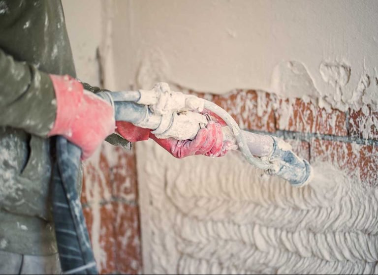 Close-up of plaster being applied to a wall.