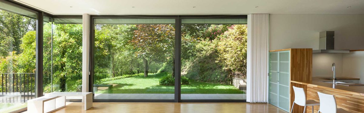 Large sliding glass doors leading to a garden, highlighting glazing installation.
