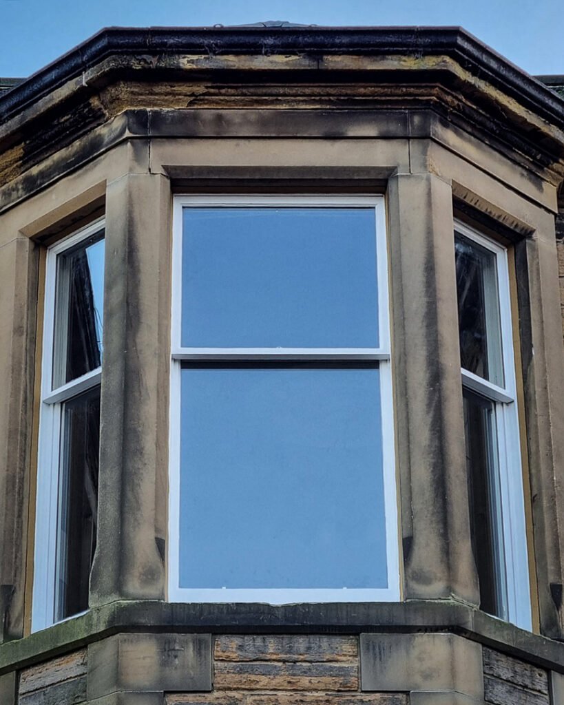 Close-up of a bay window with restored sash and case windows.