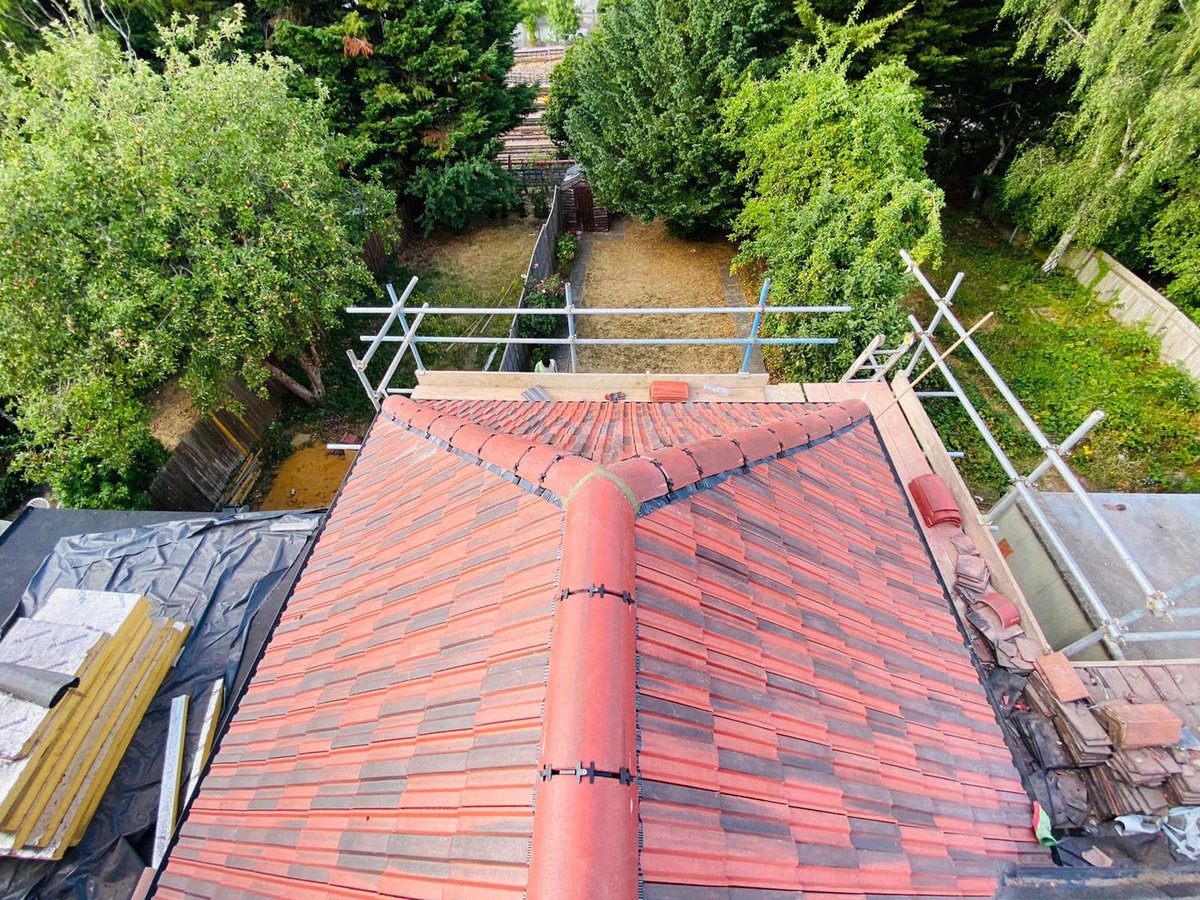 Roof with new red tiles and a central ridge, viewed from above.