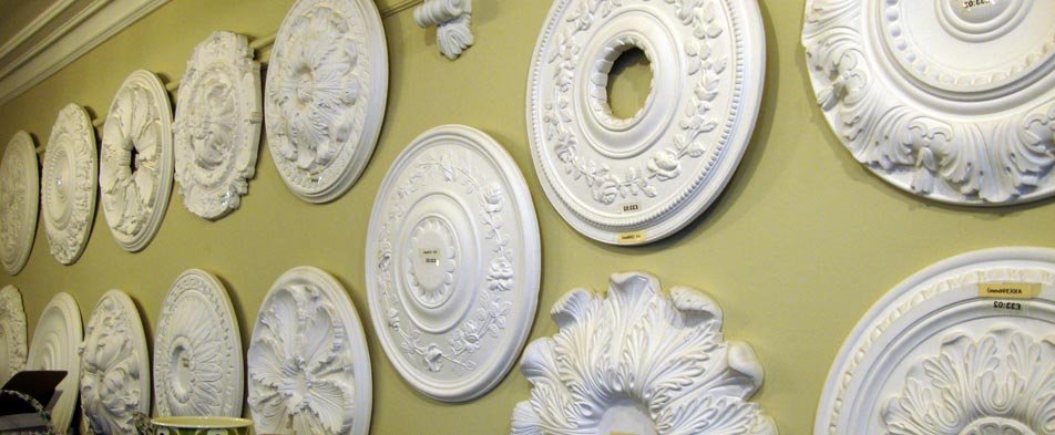 Display of various plaster ceiling roses and decorative elements.