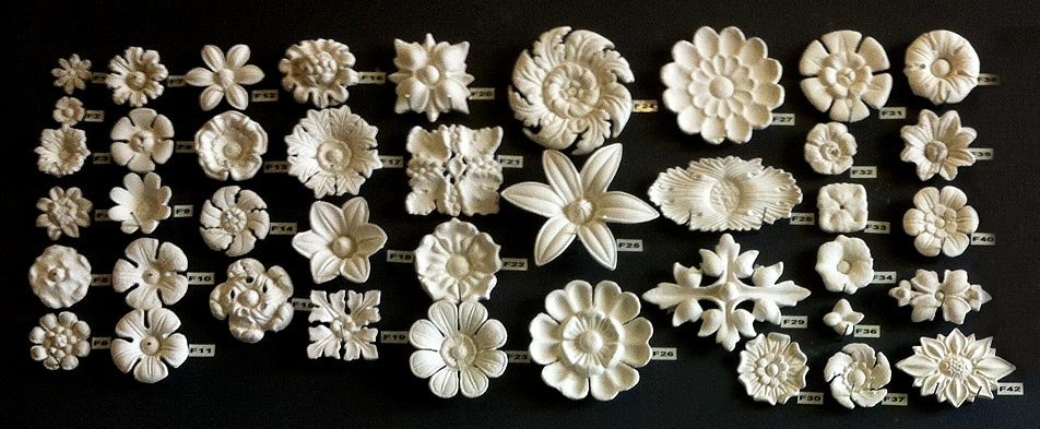 Selection of small plaster decorative elements on a black background.